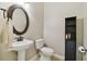 Elegant powder room featuring a pedestal sink, decorative mirror, and modern fixtures at 442 Devon Pl, Lake Mary, FL 32746