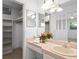 Bathroom featuring single sink, pink countertop, walk-in closet, and large mirror at 4913 E Wind St, Orlando, FL 32812
