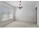 Bright dining room with a vintage chandelier, wainscoting, and a large window at 4913 E Wind St, Orlando, FL 32812
