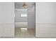 Hallway showing tile flooring and an open view into a room with a large window at 4913 E Wind St, Orlando, FL 32812