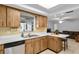 Kitchen featuring a view into the living room, stainless steel dishwasher, and ample counter space at 4913 E Wind St, Orlando, FL 32812