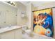Bright bathroom with a shower featuring a Beauty and the Beast themed shower curtain at 511 Coventry Rd, Davenport, FL 33897