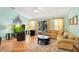 Bright living room with wood flooring, yellow sofa, and sliding glass doors to the patio at 511 Coventry Rd, Davenport, FL 33897