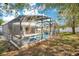 Enclosed screened-in pool and spa in backyard amongst the fall foliage at 511 Coventry Rd, Davenport, FL 33897
