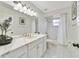 This bathroom features a white vanity with marble countertop and tiled shower at 607 S Glencoe Rd, New Smyrna Beach, FL 32168
