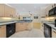 Functional kitchen with light wood cabinets, black appliances, and tiled floor at 607 S Glencoe Rd, New Smyrna Beach, FL 32168