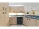 Kitchen featuring light wood cabinetry, black appliances, and ample counter space at 607 S Glencoe Rd, New Smyrna Beach, FL 32168