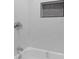 Close-up of shower with white subway tile and a recessed storage niche with dark accent tile at 624 Illinois Ave, St Cloud, FL 34769