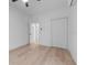 Bedroom featuring light wood flooring, white walls, a ceiling fan, closet and doorway to another room at 624 Illinois Ave, St Cloud, FL 34769