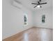 Bright bedroom featuring light wood flooring, large windows, a ceiling fan, and an air conditioning unit at 624 Illinois Ave, St Cloud, FL 34769