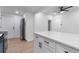 Open kitchen design with white cabinets, island, and stainless steel refrigerator at 624 Illinois Ave, St Cloud, FL 34769
