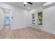 Room with light wood flooring, white walls and trim, with view through two windows to the outdoors at 624 Illinois Ave, St Cloud, FL 34769
