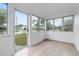 Sunroom featuring wood-look flooring and a glass door with windows showcasing views of the outdoors at 624 Illinois Ave, St Cloud, FL 34769