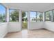 Bright sunroom featuring wood-look flooring and large windows offering neighborhood views at 624 Illinois Ave, St Cloud, FL 34769