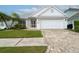 Charming single-story home featuring a well-manicured lawn, palm trees, and a two-car garage at 6425 Streamport Dr, Orlando, FL 32822