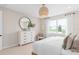 Bedroom with neutral decor, a large dresser, and a circular mirror on the wall at 6920 Dappled Oak Way, Orlando, FL 32829