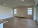 Open-concept living room with hardwood flooring, recessed lighting, and large windows at 6920 Dappled Oak Way, Orlando, FL 32829