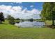 Scenic community pond reflecting the blue sky and clouds, surrounded by lush greenery at 843 Julliard Ct, Orlando, FL 32828