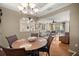Open dining room with hardwood floors, elegant chandelier, and views into the living room at 8712 Sw 83Rd Cir, Ocala, FL 34481