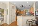 Well-lit kitchen with bar seating and stainless-steel appliances transitions into living area and bedroom at 8712 Sw 83Rd Cir, Ocala, FL 34481