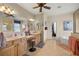 Main bathroom featuring double sinks, vanity seating, and walk in closet at 8712 Sw 83Rd Cir, Ocala, FL 34481