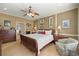 Spacious main bedroom featuring a cozy sitting area, ceiling fan, and tasteful decor at 8712 Sw 83Rd Cir, Ocala, FL 34481