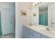 Bright bathroom featuring a double vanity, a large mirror, and a tiled shower at 100 Diamond Ridge Blvd, Auburndale, FL 33823