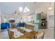 Open-concept kitchen with gray cabinets, granite counters, tile floors, and a seamless transition into the dining area at 100 Diamond Ridge Blvd, Auburndale, FL 33823