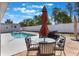 Inviting pool area featuring a table with umbrella, and chairs for outdoor dining and relaxing by the pool at 100 Diamond Ridge Blvd, Auburndale, FL 33823