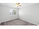 Neutral bedroom showcases a large window, plush carpeting, and a ceiling fan at 1096 Ballyshannon Pkwy, Orlando, FL 32828