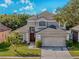 Charming two-story home with well-maintained lawn, mature trees, and attached two-car garage at 1096 Ballyshannon Pkwy, Orlando, FL 32828