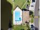 Aerial top-down view of fenced community pool adjacent to parking and pond at 112 Windtree Ln # 203, Winter Garden, FL 34787