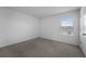 Simple bedroom with neutral carpet and a window, providing a calm and inviting space at 1171 Lone Palm Way, St Cloud, FL 34771