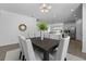 The dining room table is set beneath a modern lighting fixture with an oval mirror on the wall at 1171 Lone Palm Way, St Cloud, FL 34771