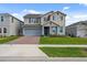 Lovely two-story home with a gray exterior, manicured lawn, and brick-paver driveway at 1171 Lone Palm Way, St Cloud, FL 34771