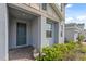 Gray home exterior featuring a blue front door, brick-paved entry, and manicured shrubbery at 1171 Lone Palm Way, St Cloud, FL 34771