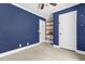 Bedroom featuring navy walls, built-in shelving, and carpeting at 11811 Kijik Trl, Groveland, FL 34736