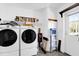 Practical laundry room featuring modern washer and dryer units, complemented by functional storage solutions at 11811 Kijik Trl, Groveland, FL 34736