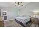 Relaxing bedroom featuring a ceiling fan, wood-look flooring and ensuite access at 12419 Eryn Ct, Clermont, FL 34711