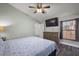 Comfortable bedroom boasts wood-look floors, ceiling fan, natural light, and a TV at 12419 Eryn Ct, Clermont, FL 34711