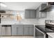 Bright kitchen featuring stainless steel appliances, gray cabinetry, and quartz countertops at 1269 Winter Green Way, Winter Garden, FL 34787