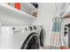 Neat laundry area with white washer and dryer, plus shelving for storage at 1269 Winter Green Way, Winter Garden, FL 34787