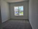 Carpeted bedroom with a large window offering natural light and views of the surrounding neighborhood at 13217 Tollcross Way, Winter Garden, FL 34787