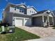 Two-story home with a two-car garage and a welcoming front porch at 13217 Tollcross Way, Winter Garden, FL 34787