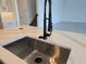 Close-up of kitchen island with modern faucet and countertop at 13217 Tollcross Way, Winter Garden, FL 34787