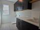 Laundry room featuring black cabinets, white countertops, and a window at 13217 Tollcross Way, Winter Garden, FL 34787