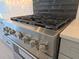 Close up of a stainless steel oven and range with modern knobs and a black backsplash at 13217 Tollcross Way, Winter Garden, FL 34787