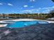 A large pool with an attached hot tub overlooks a tranquil lake at 13217 Tollcross Way, Winter Garden, FL 34787