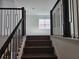 Staircase with dark wood treads and ornamental railing leads to the upstairs at 13217 Tollcross Way, Winter Garden, FL 34787