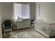 Bright Bedroom with white crib, dresser changing table, chair and ottoman next to large window at 14020 Sanibel Isle Dr, Orlando, FL 32824